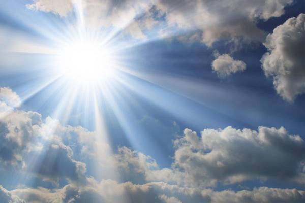 Sonnenstrahlen scheinen durch Wolken hindurch am Himmel