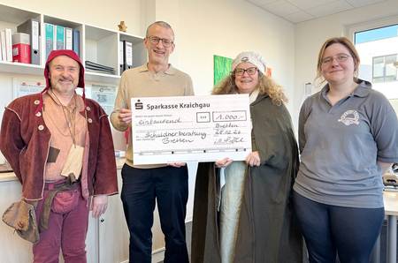 Drei Mitglieder des Fahrenden Volks mit Spendenscheck